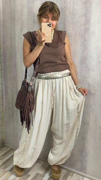 Pantalón bombacho beige con tachas en los laterales
