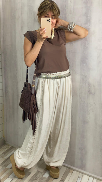 Pantalón bombacho beige con tachas en los laterales